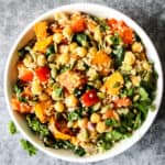Sweet potato quinoa salad with chickpeas and spinach in a white bowl.