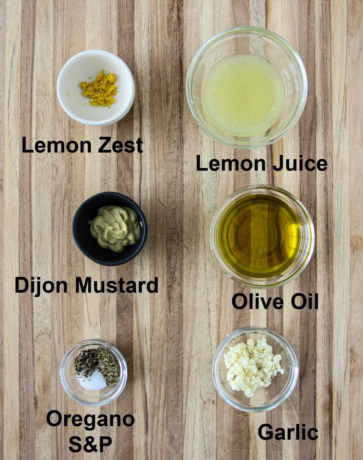 The ingredients for the salad dressing in glass bowls.