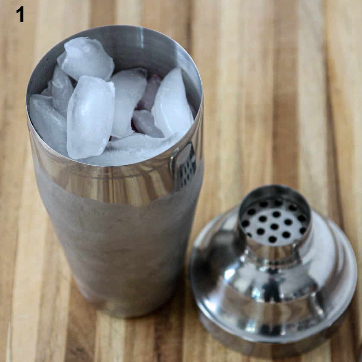 A stainless steel cocktail shaker filled with ice.