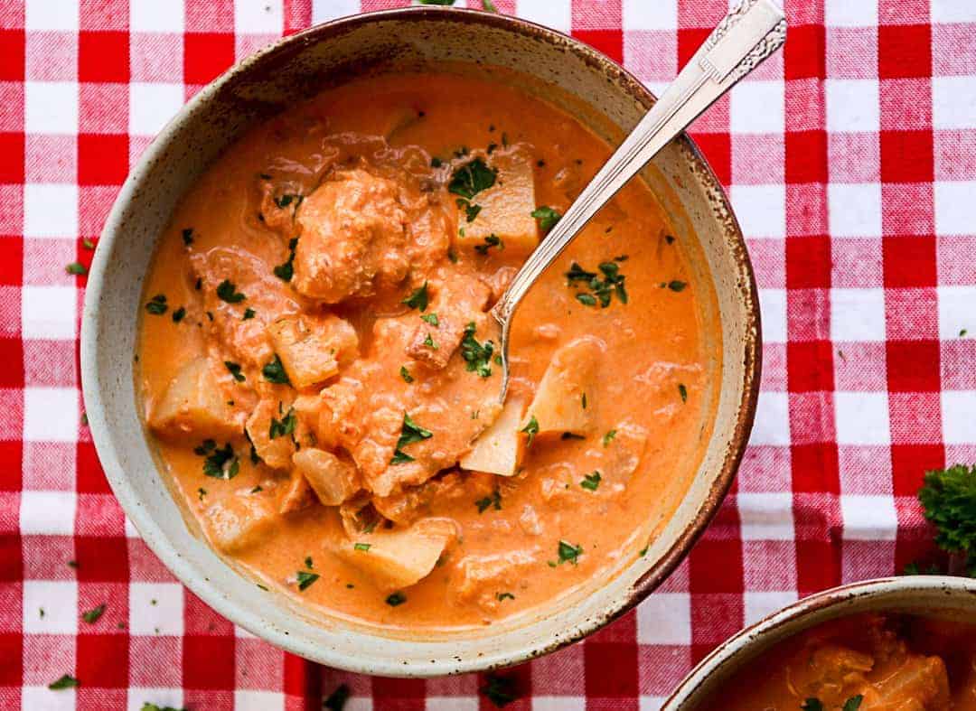 A bowl of soup with a spoon in it on a table