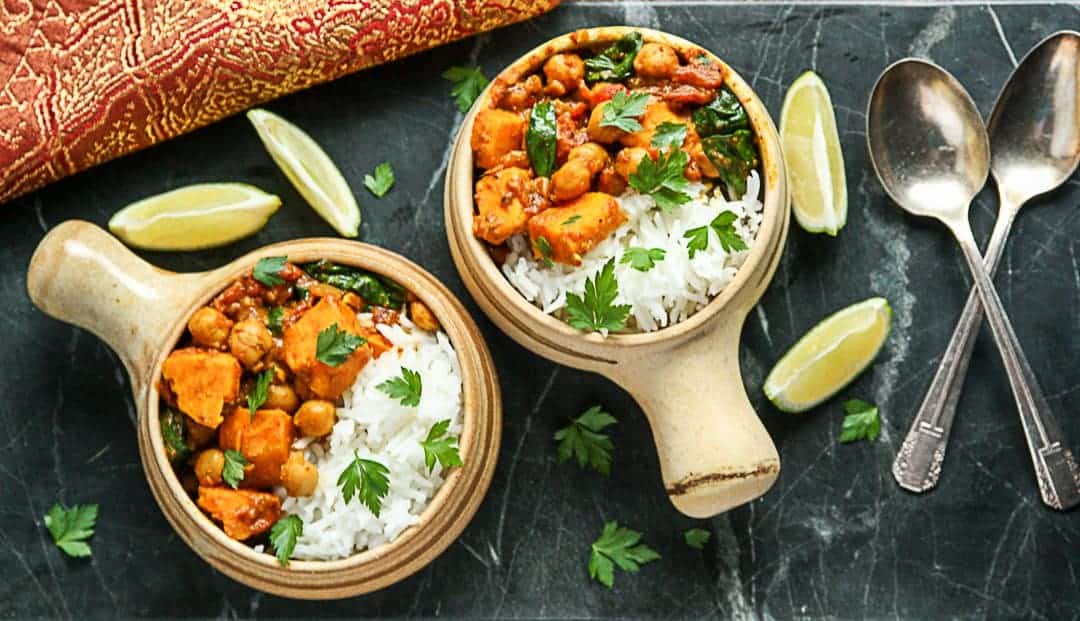 Two bowls of curry and rice on a countertop