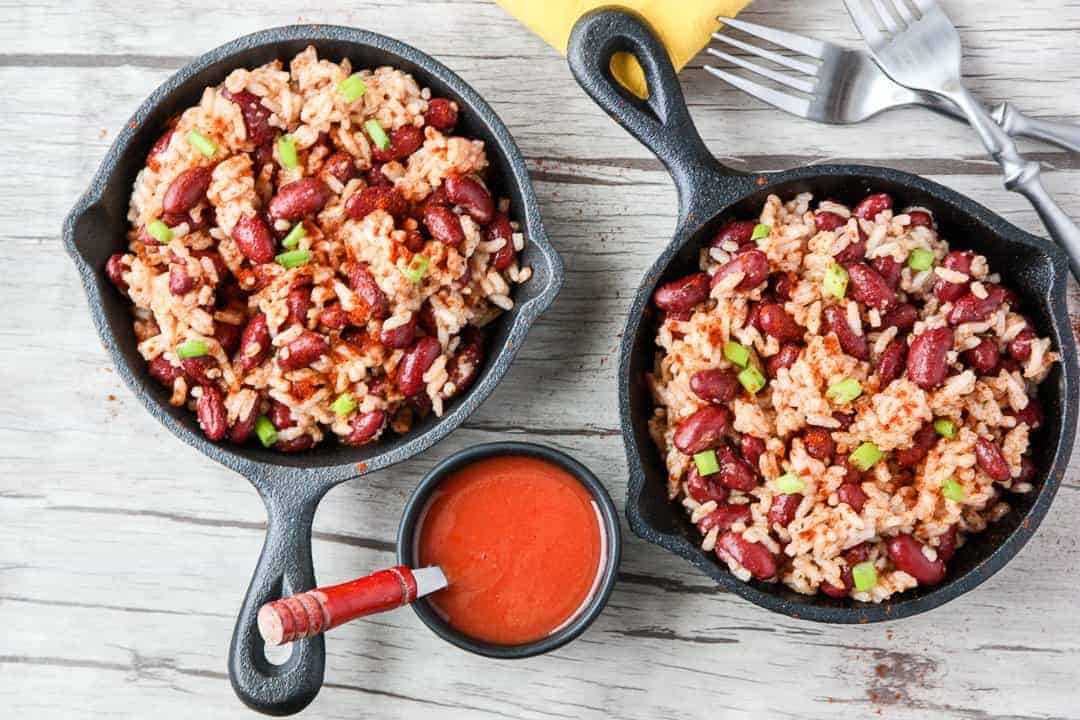 Red beans and rice in small black skillet on wooden table