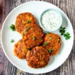 Several salmon patties on a white plate.