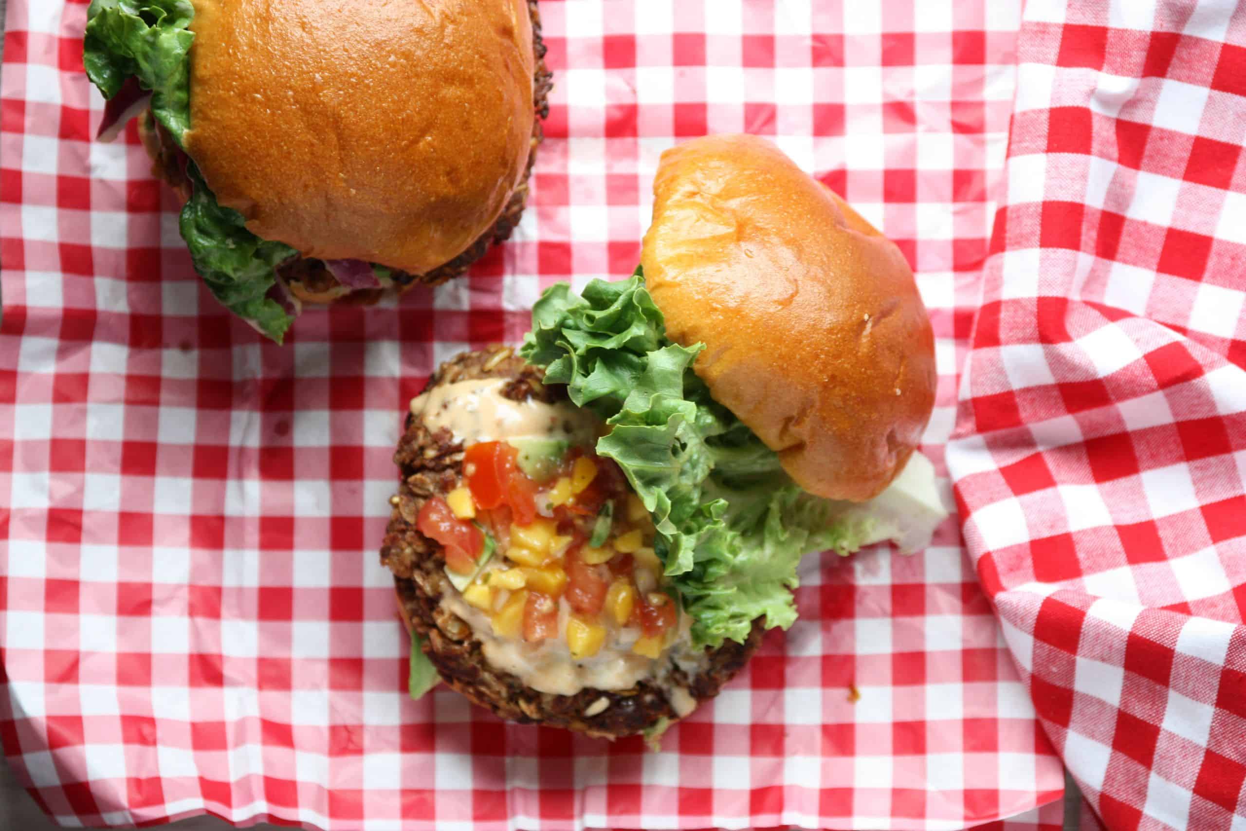 A burger with the top bun removed, sitting on top of a table