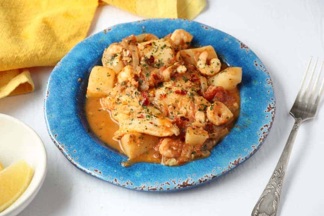 Spanish fish stew on a blue plate