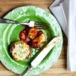 A plate of food sitting on top of a wooden table, with Stuffed mushrooms