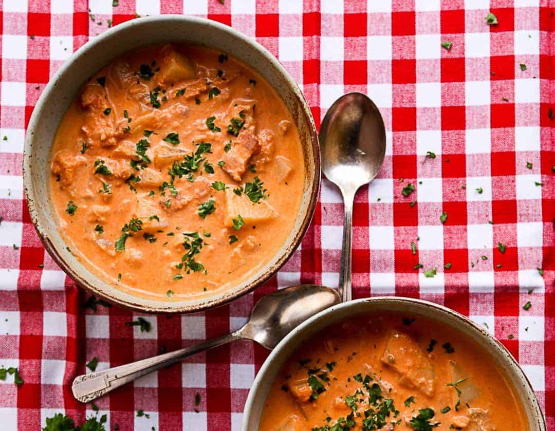 A bowl of soup and two spoons on a table