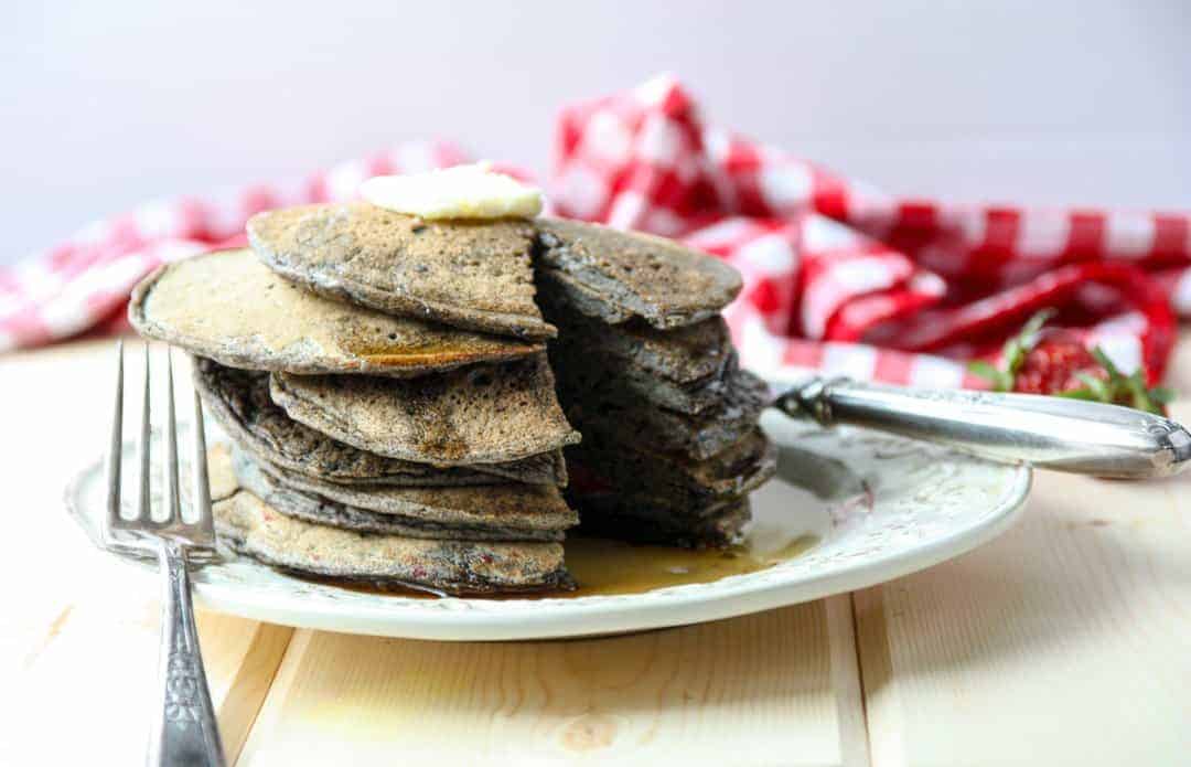 A stack of pancakes on a plate, with syrup