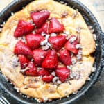 Top shot of baked and strawberry filled German pancake in cast iron skillet.