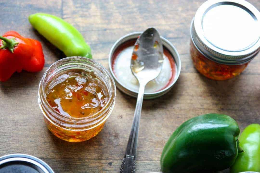An open jar of pepper jelly with a spoon