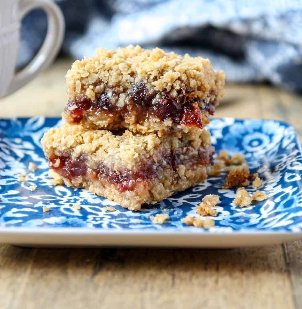 Two cranberry date squares on a blue & white plate.