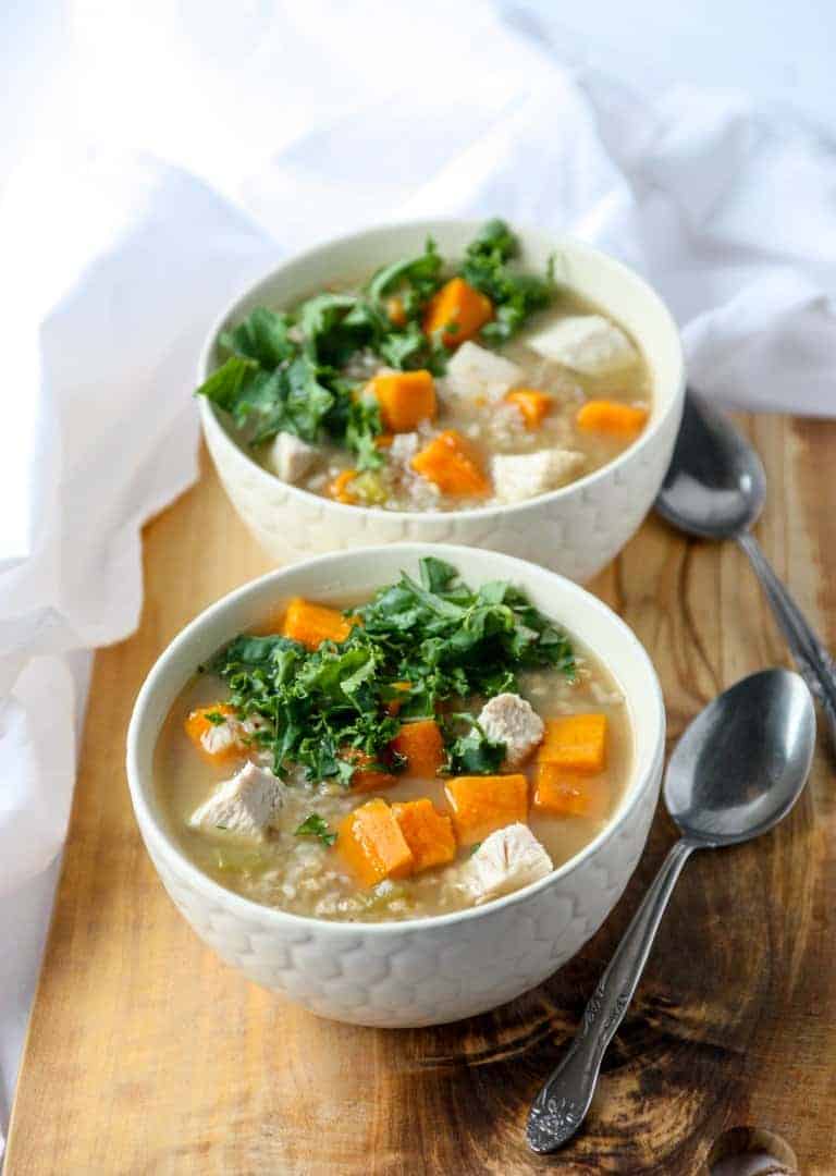 Two bowls of soup on a table with two spoons