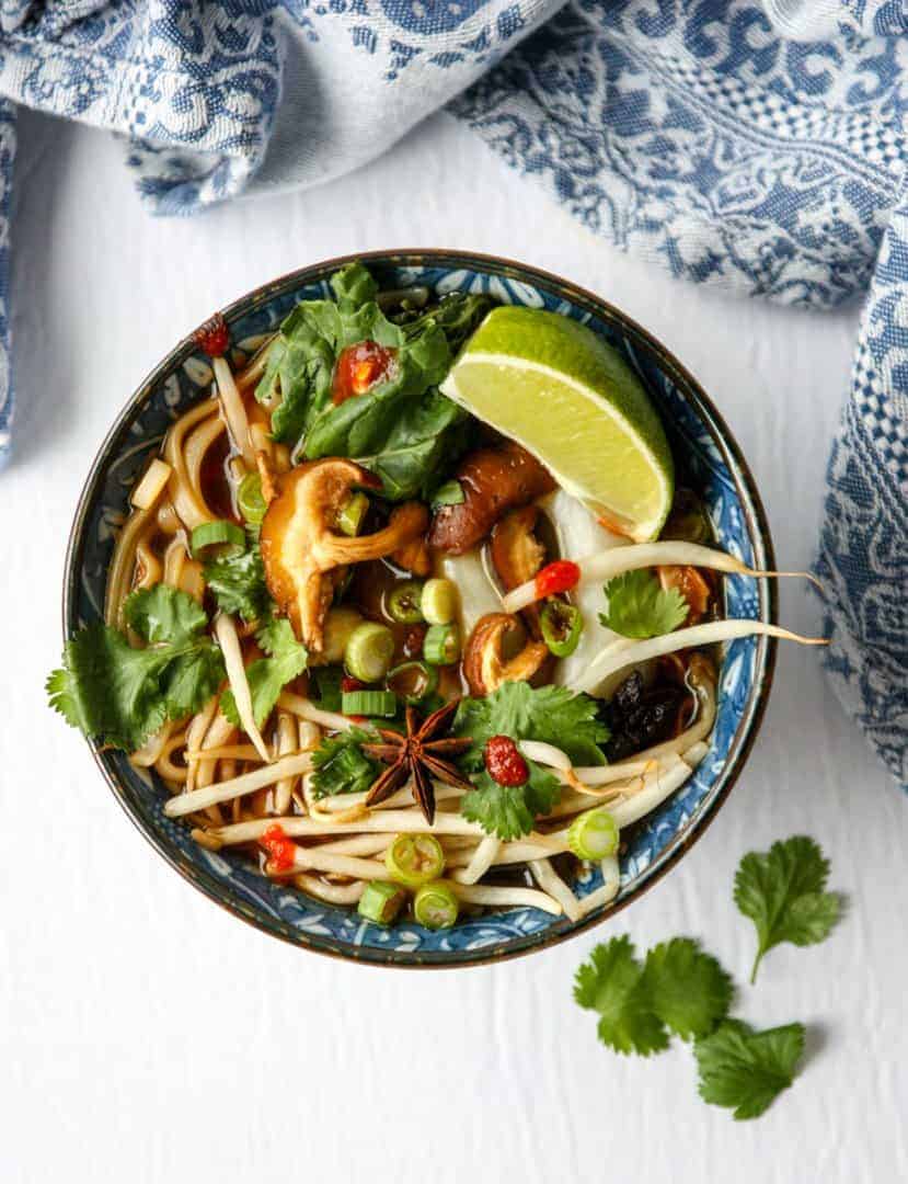 top shot of Vietnamese soup in bowl with lemon wedge
