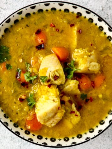 Turkey lentil soup in a black and white bowl.