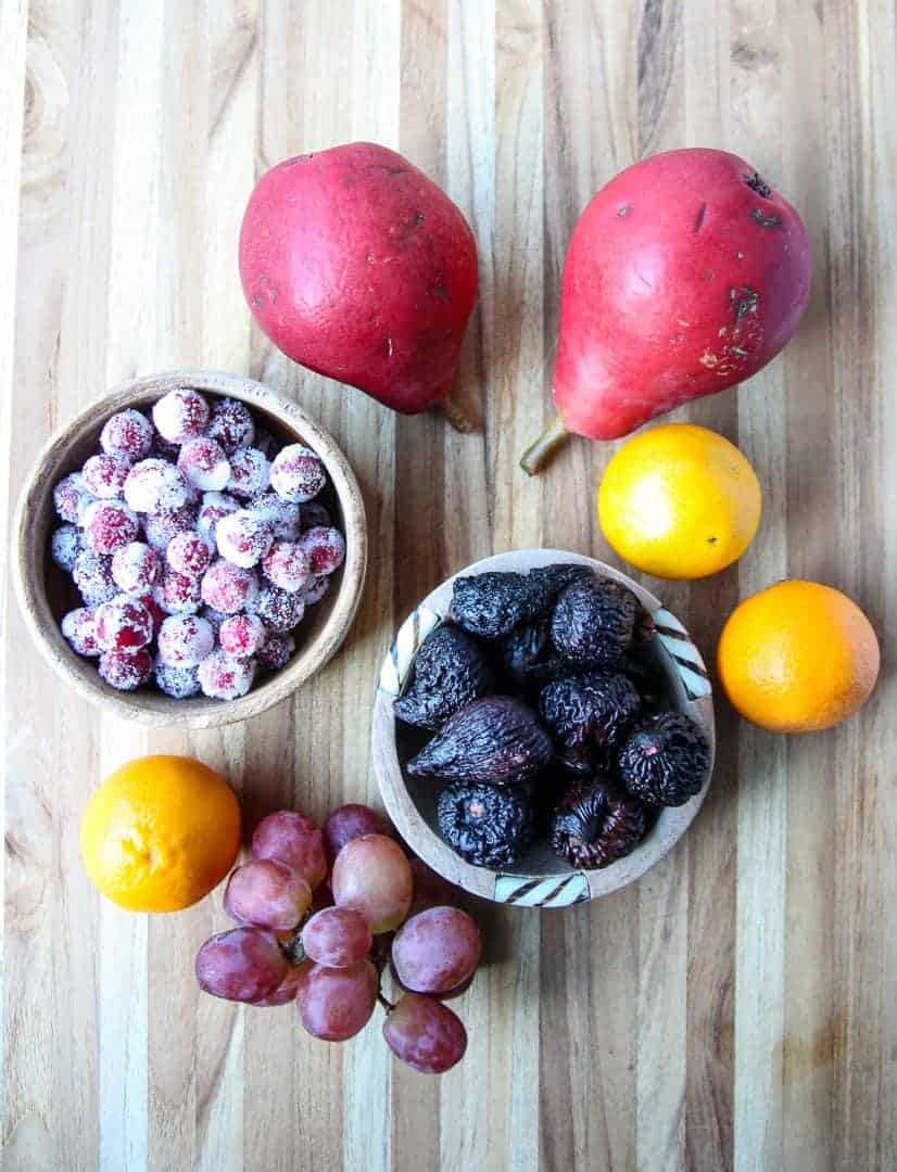 Serveral different pieces of fruitf on a wooden cutting board