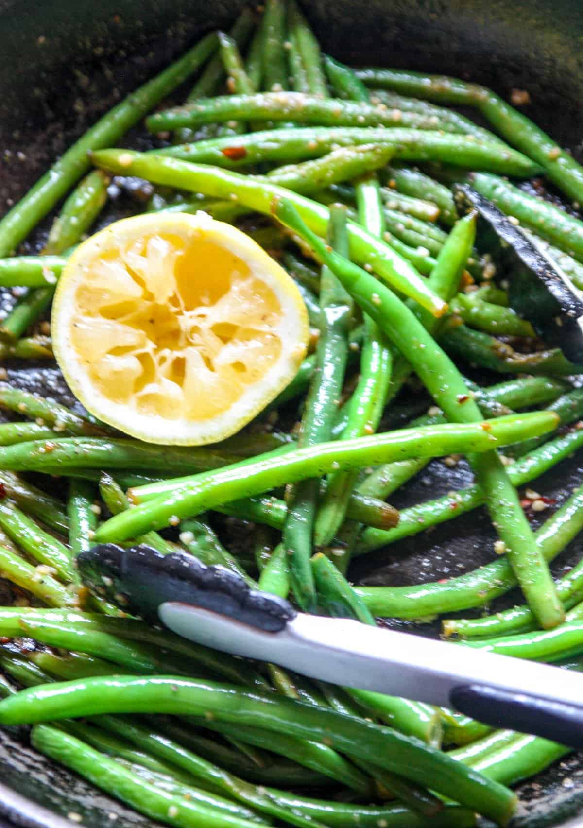 Close up of cooked string beans in a skillet.