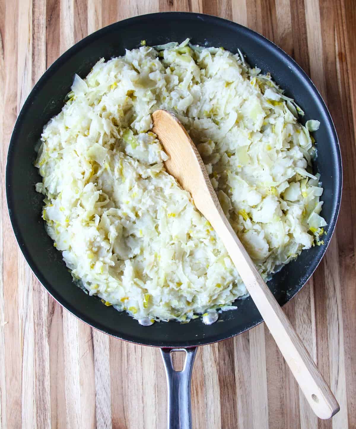Mashed potatoes and cabbage combined in a skillet.