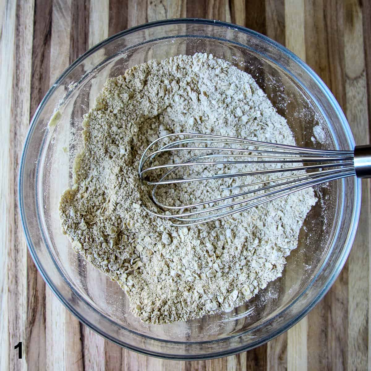 Ingredients being whisked together in a glass bowl.