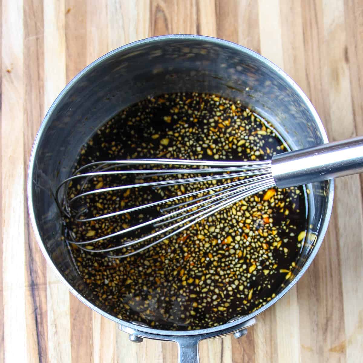 Ingredients being whisked together in a saucepan.