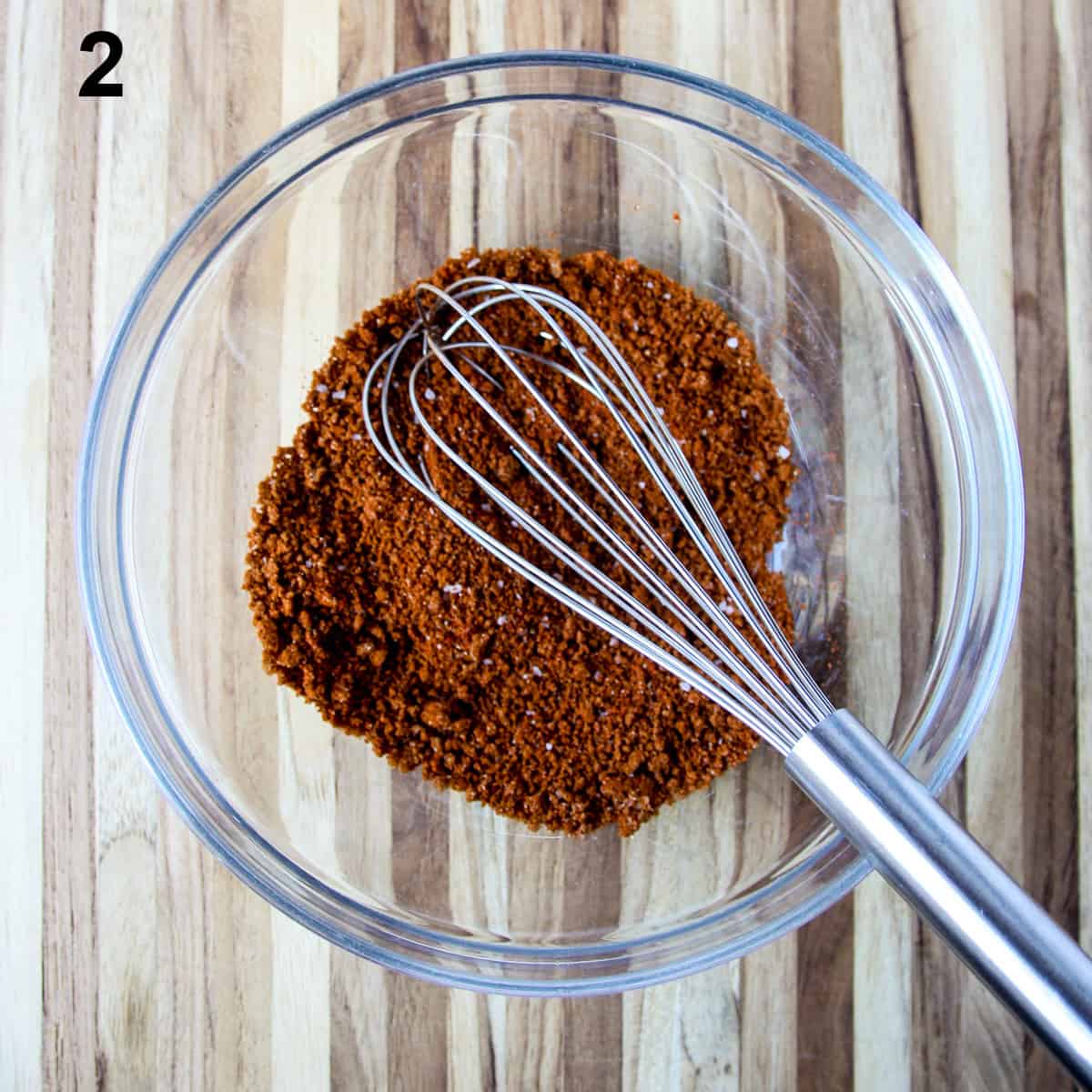 The seasoning rub ingredients being whisked together in a bowl.