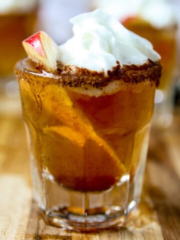 An apple pie shot garnished with an apple slice.