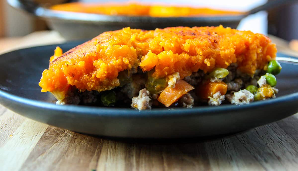 A close up of one serving of the dish on a black plate.