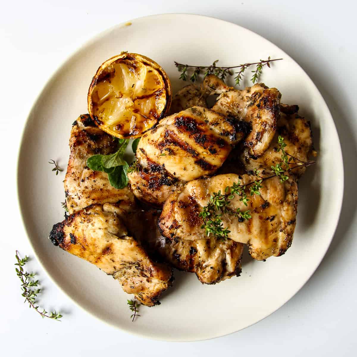 Grilled Boneless Chicken Thighs on a white plate.