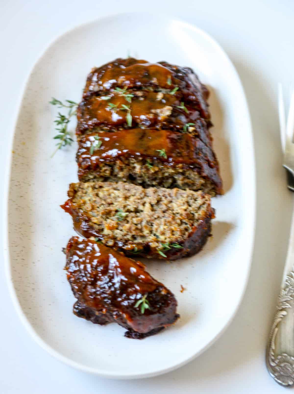 Sliced meatloaf on a white plate.