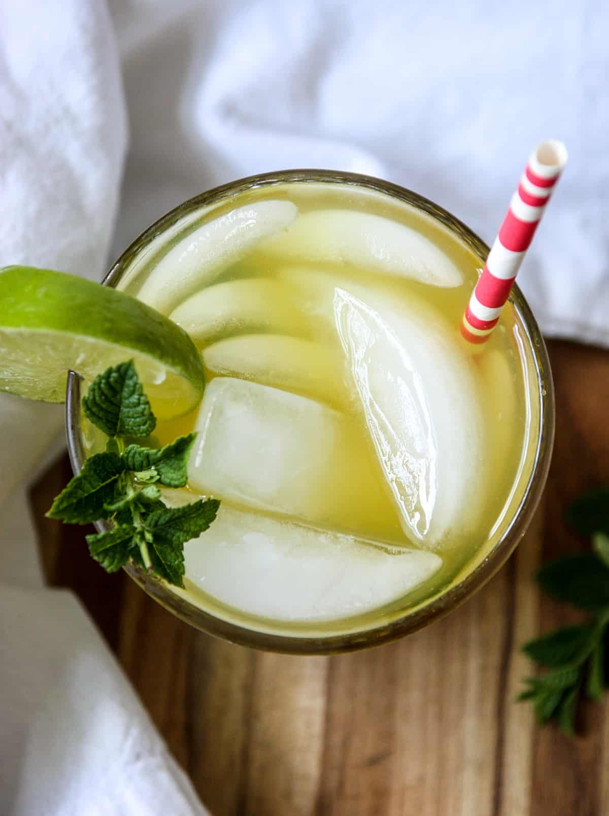 Top down view of  the cocktail glass garnished with mint leaves and a lime wedge.
