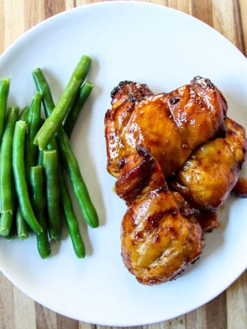 Air Fried Teriyaki Chicken on a white plate with green beans.