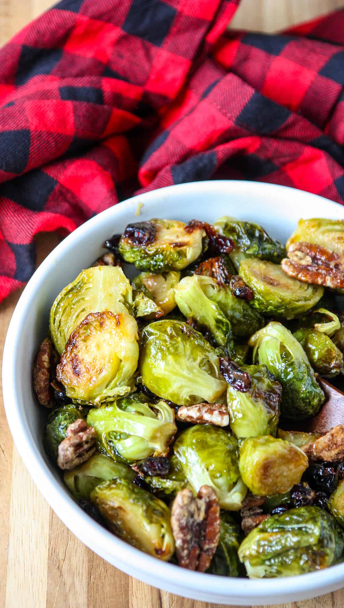 The brussels sprouts, pecans and cranberries in a white dish. 