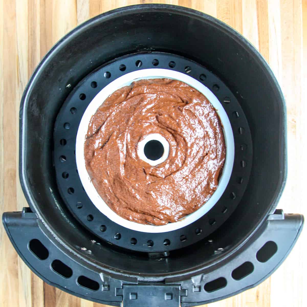 The filled cake pan in the air fryer basket.
