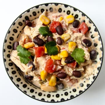 A black and white bowl filled with cream cheese chicken chili.