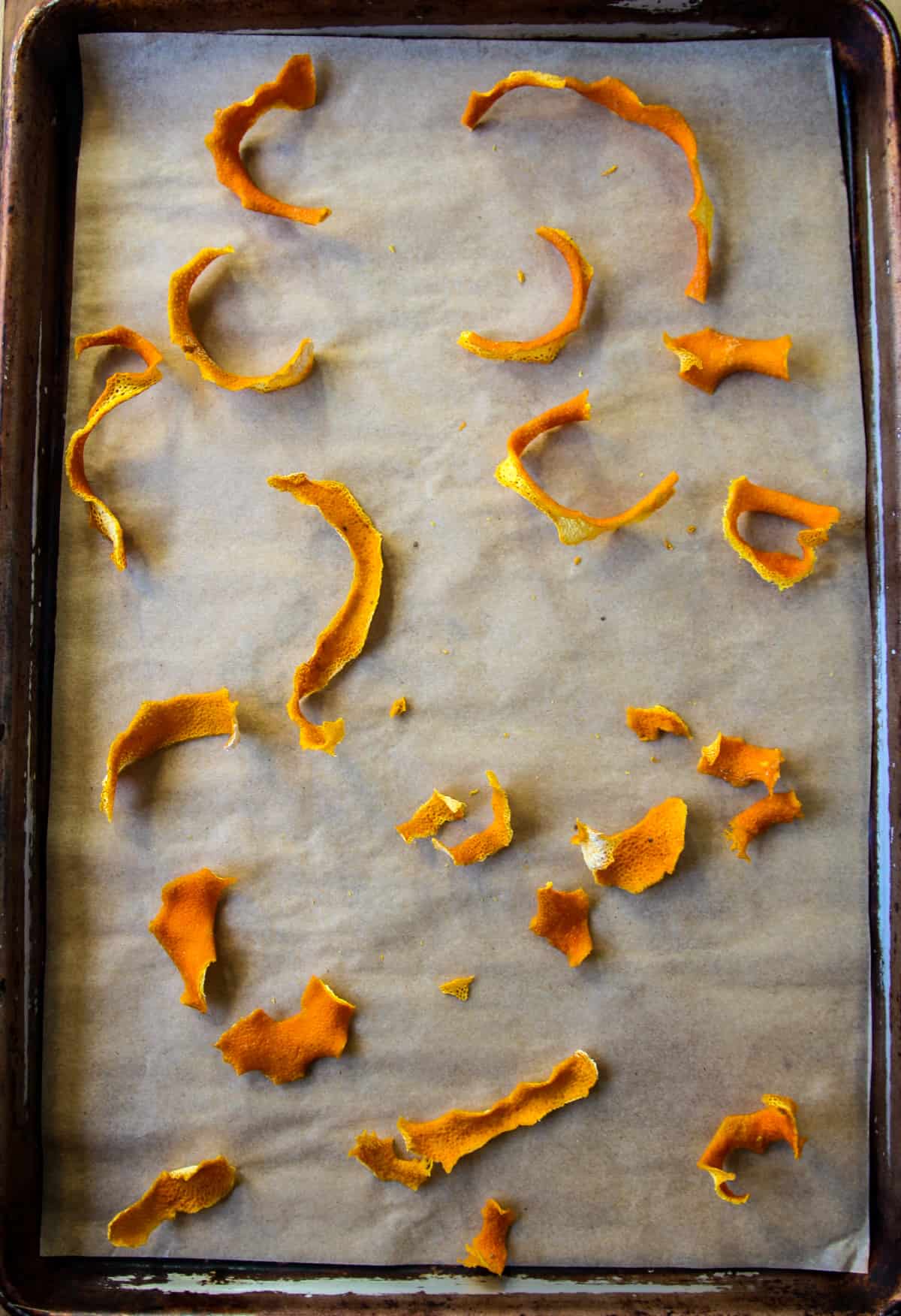 Dried orange peel strips on a baking tray.