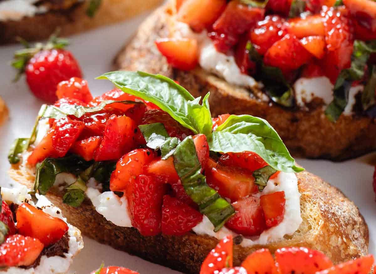 Strawberry bruschetta crostini appetizers with basil garnish.