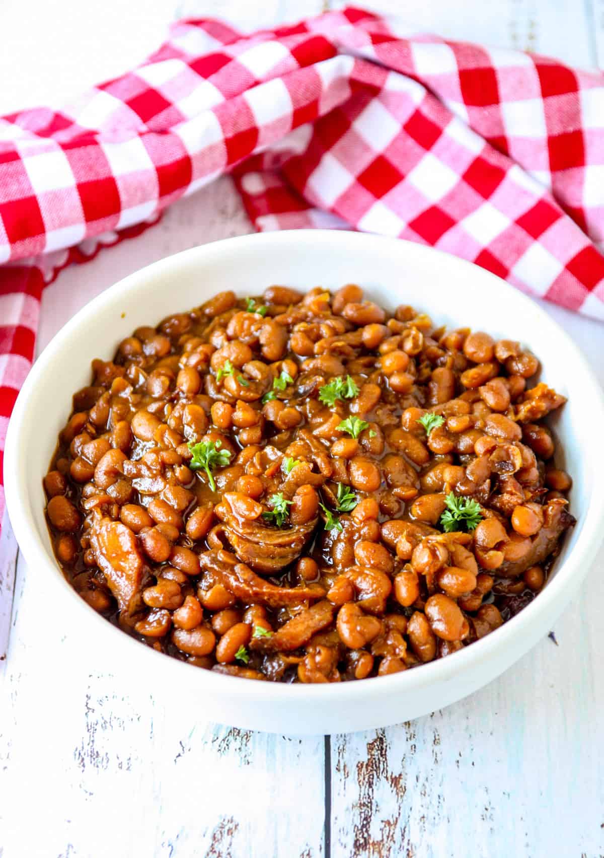Slow cooked baked beans in a white bowl.
