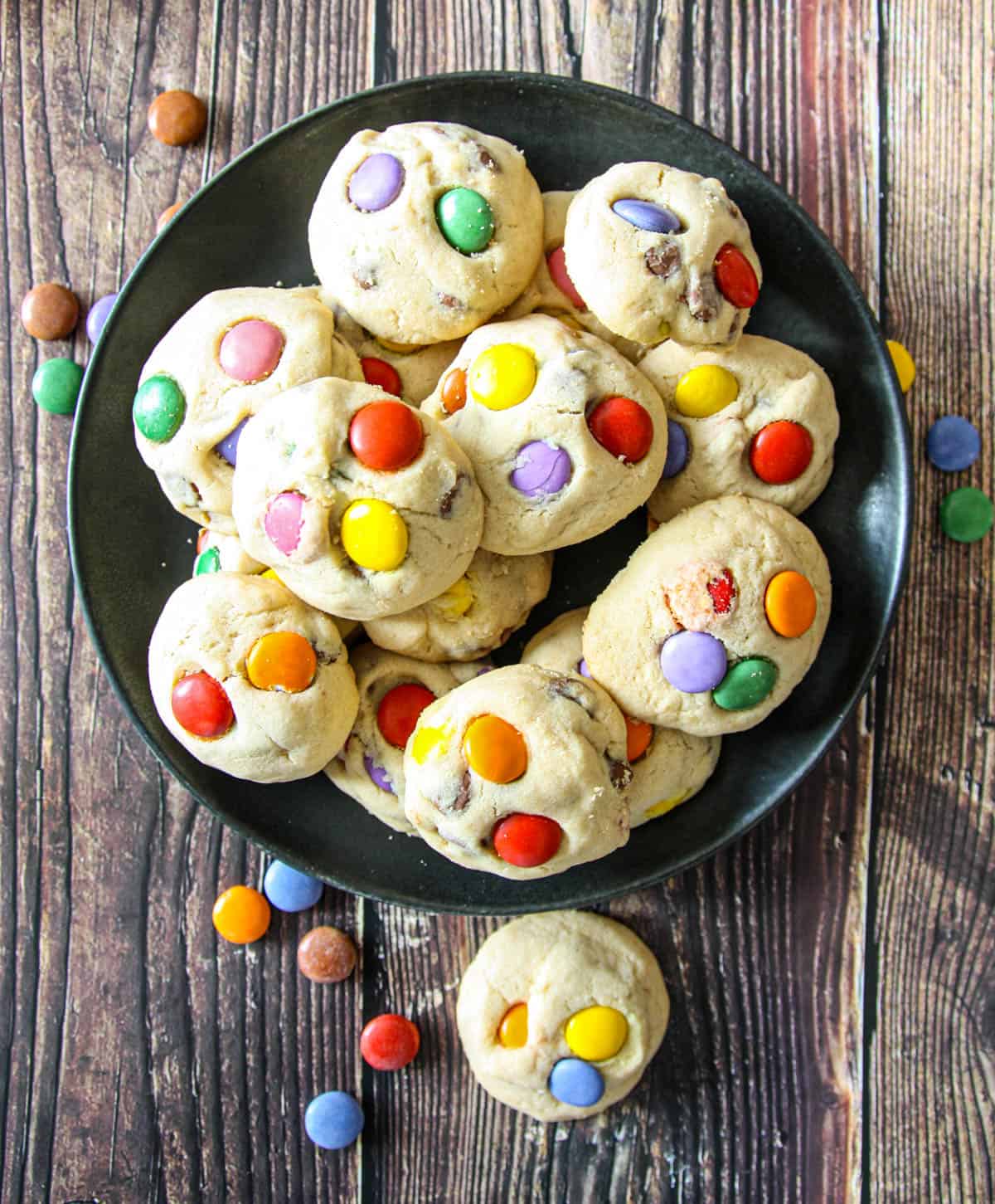A black plate filled with Smarties cookies.