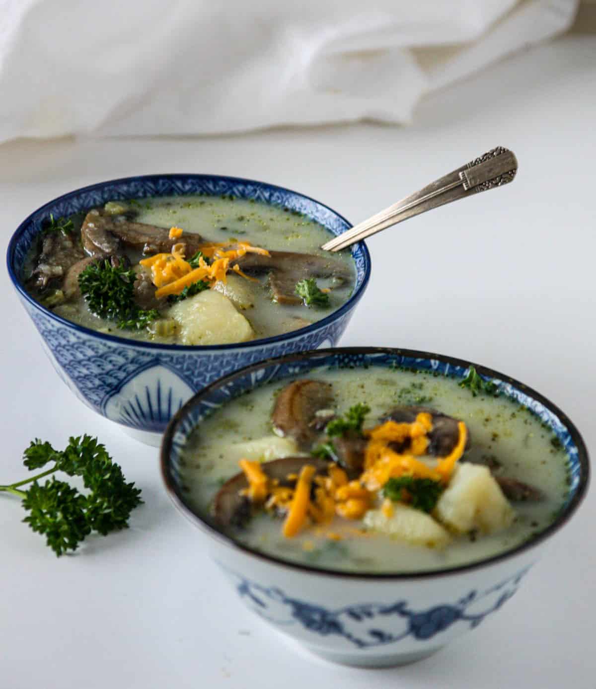Potato mushroom soup in two blue and white bowls.