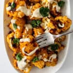 Roasted cauliflower drizzled with tahini sauce.