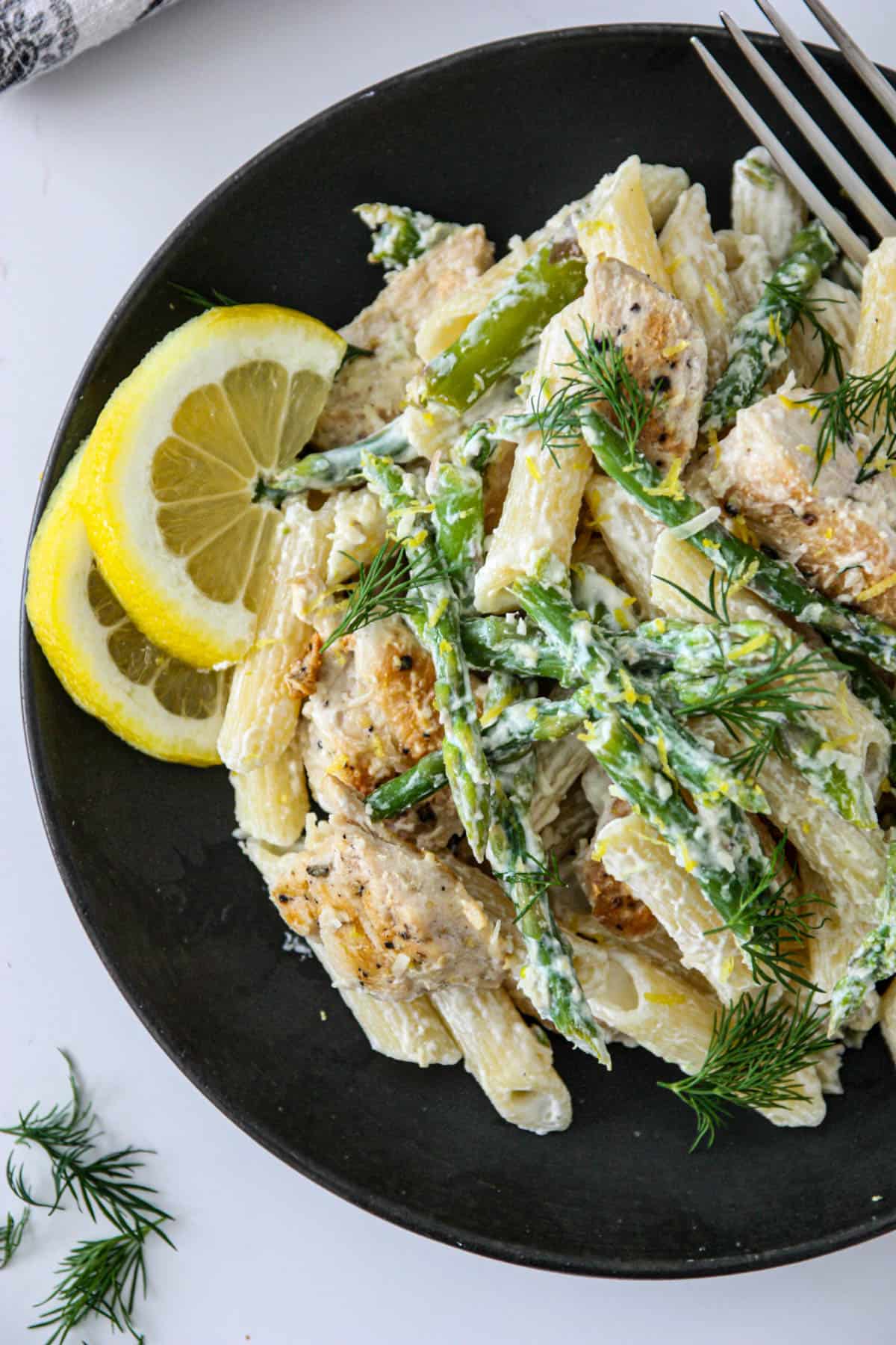 Asparagus and chicken pasta garnished with fresh dill.