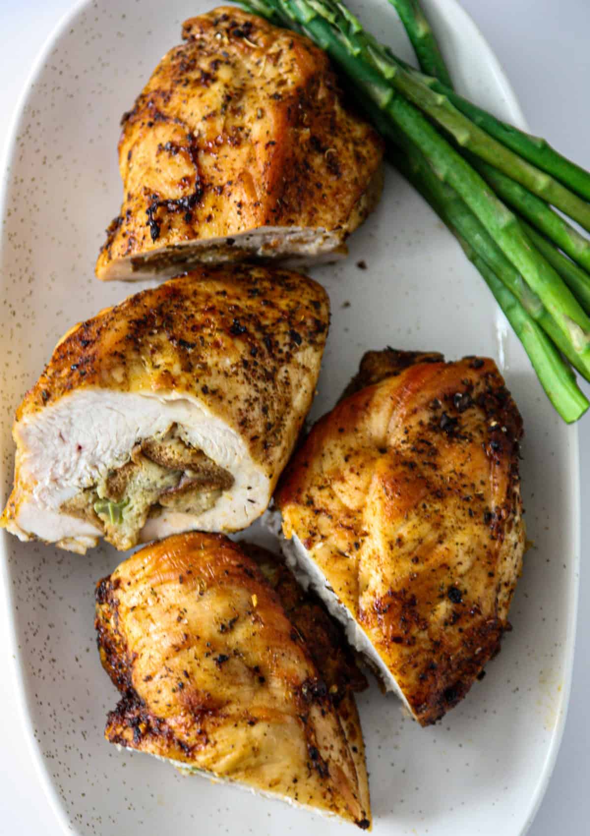 Sliced stuffed chicken breast with stuffing on a white plate.