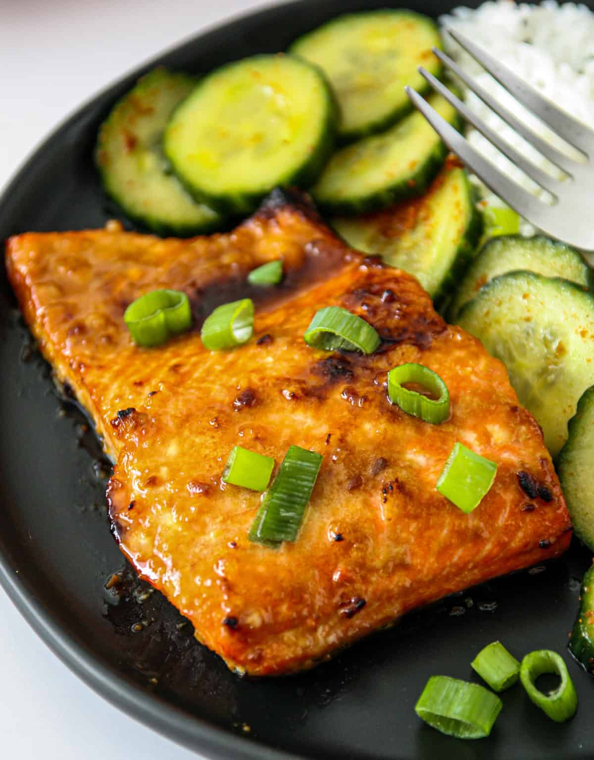 A fillet of miso butter salmon, garnished with green onion slices.